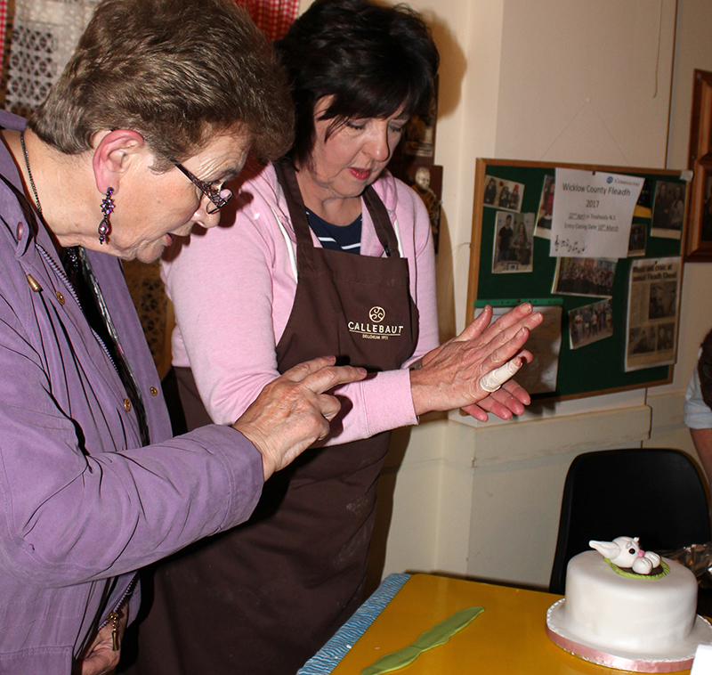 Mary Finlay watches Jennifer Doyle modelling a rabbit with white icing