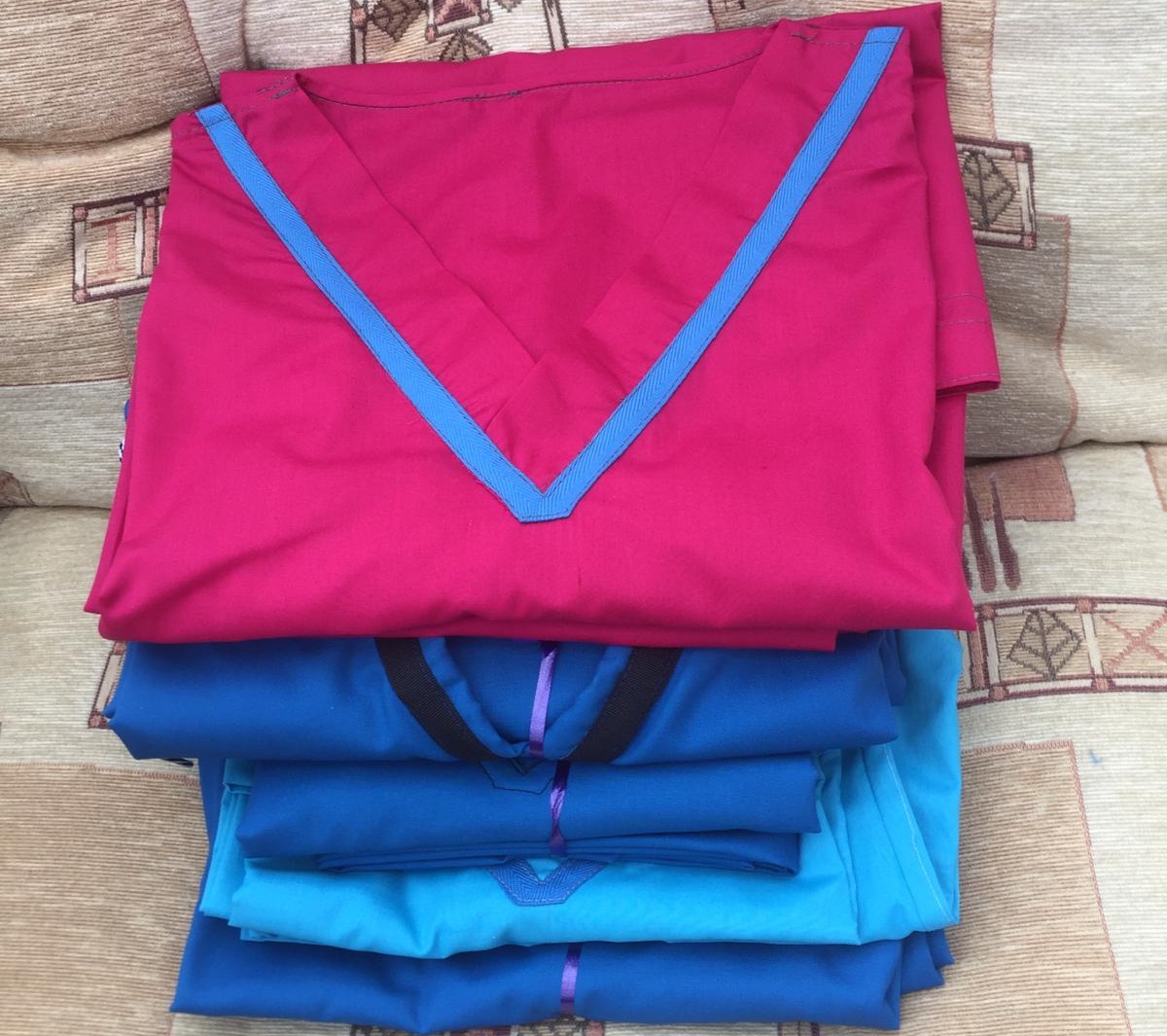 pile of folded scrubs in blue and bright pink colours